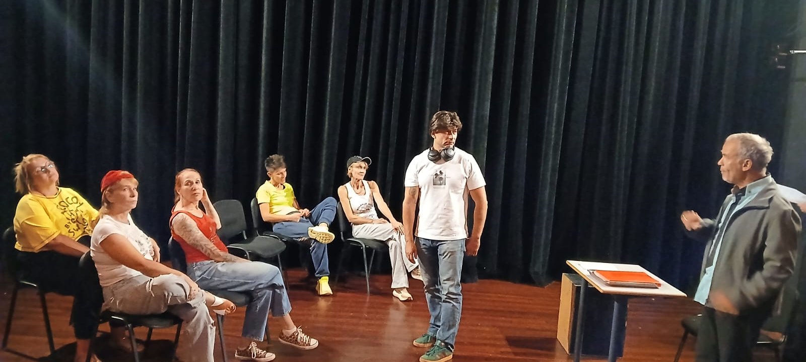 Groupe d'adultes en atelier, debout en cercle sur un plateau