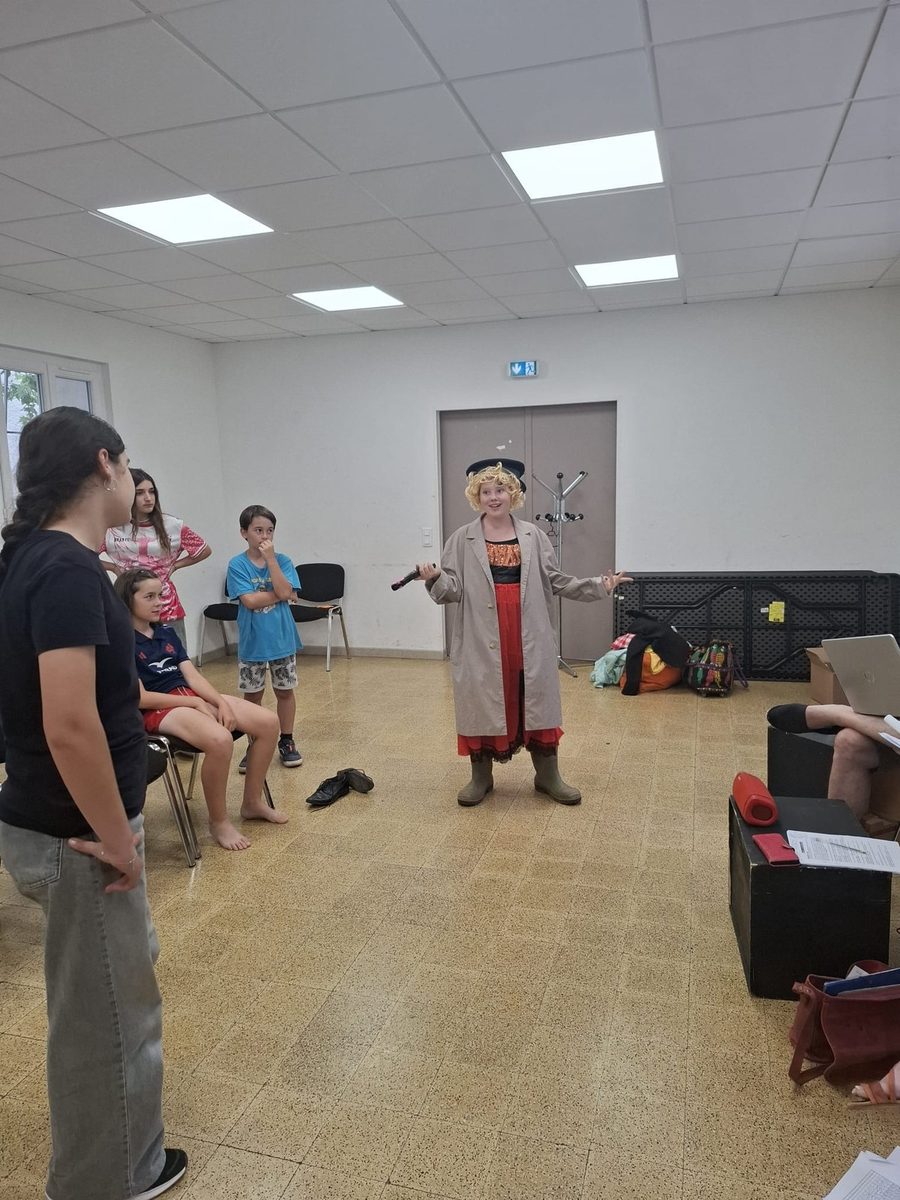 Un personnage costumé face à un groupe de jeunes pendant un stage