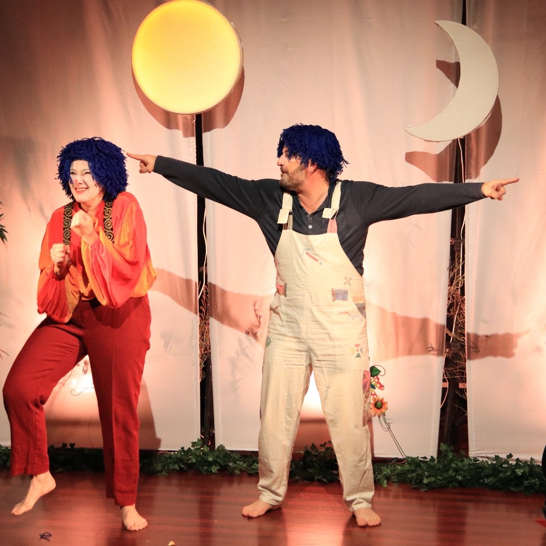 Deux comédiens en clowns, perruques bleues, entre un soleil et une lune de carton